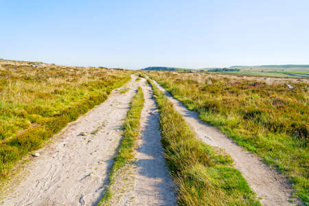 Rutted dirt road across moorland behind Baslow Edge on a hazy morning