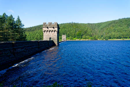 Rippled waters of the Derwent Reservoir washing gently against the top of Derwent Dam in Derbyshire