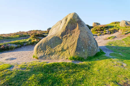 Large multicoloured Derbyshire gritstone rock on Higger Tor in the early morning sunlightの写真素材