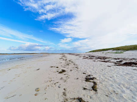 On the white sands of Plage Sainte-Marguerite at low tide a line of seaweed leads off in to the distance across the beachの写真素材