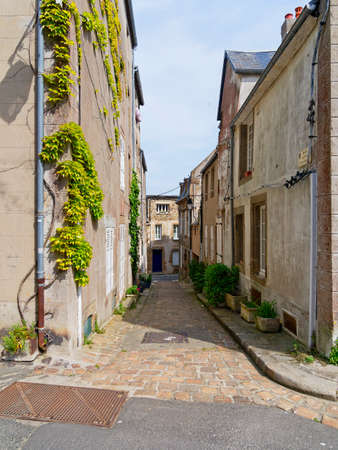 Ivy grows up the walls of old houses in a deserted narrow alley in the town of Granville, Normandy, France.のeditorial素材