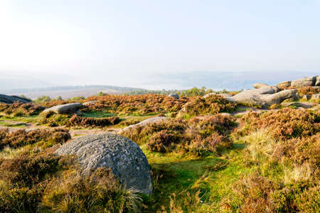 A misty autumn morning on Surprise View in the Derbyshire Peak District. An unfinished millstone is...