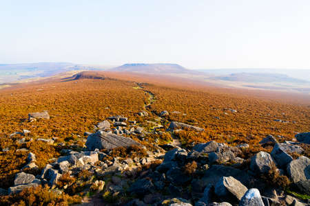 A blanket of mist lingers over the Derbyshire Peak District on a bright, sunny autumn morning.