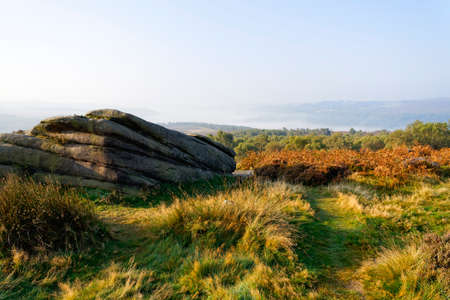 Among the gritstone rocks and bracken of Surprise view on a misty autumn morning in Derbyshire.