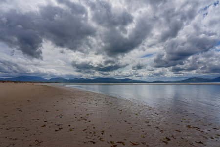 Dark rain clouds across a deserted Llanddwyn beach, Anglesey, Wales.の写真素材