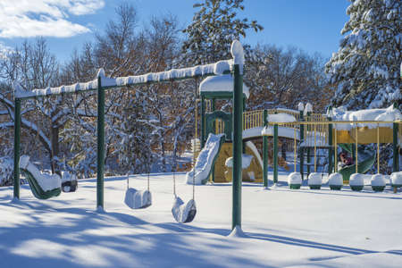 a winter playground gives way to a girl plowing down a slide, bunker hills regional park, minnesota.