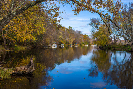 pontoon boats line the backwater banks of the st.croix river in autumn, in the village of marine on the st. croix, minnesota.の写真素材