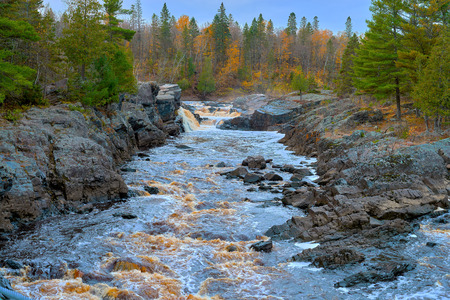 the st. louis river narrows through a small rocky gorge, creating swift moving rapids, jay cook state park, minnesota, autumn.の写真素材