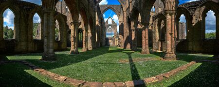 opened to the skys, a panoramic view of the interior of tintern abbey, shows a cross made from contrails above, tintern, wales.a cross made of contrails rises aboveの写真素材