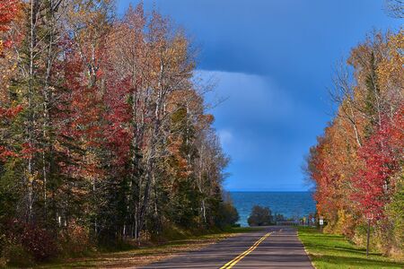 looking down meyers beach road in autumn, toward lake superior, near cornucopia, wisconsin.の写真素材