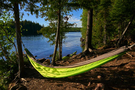 a hammock hangs in front of a kayak, on brule lake, in the boundery water canoe area wilderness, minnesota.の写真素材