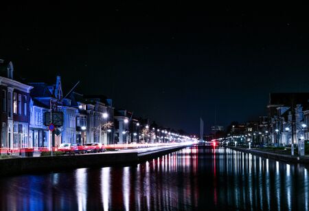 Car's are chasing their lights along a typical Dutch canal in the city of Assen in the Netherlands....