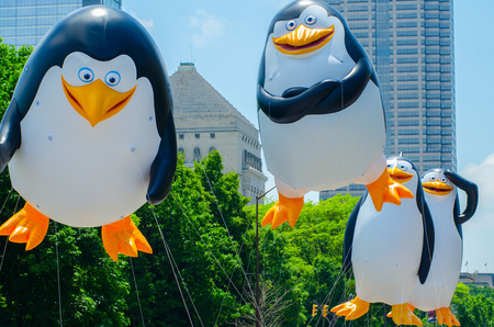 INDIANAPOLIS, IN - May 27, 2017: Giant inflatable penguins tethered by ropes float their way down North Meridian Street during the annual Indianapolis 500 Festival parade Memorial Day weekend.のeditorial素材