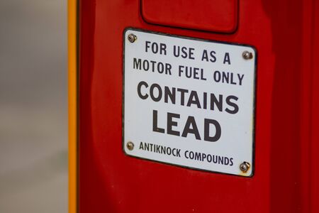 WAWPECONG, IN - APRIL 13, 2019: A vintage lead gasoline warning sign on an antique gas pump at the...
