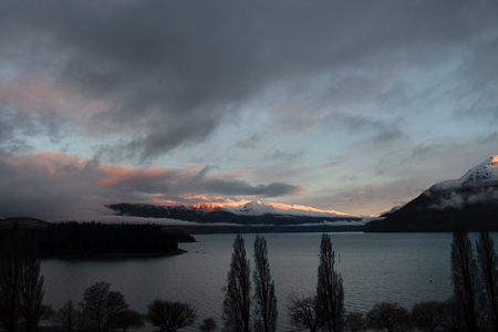 Sunset accross peaks of remarkables mountain range and lake wakitipu, queenstown, new zealandの写真素材