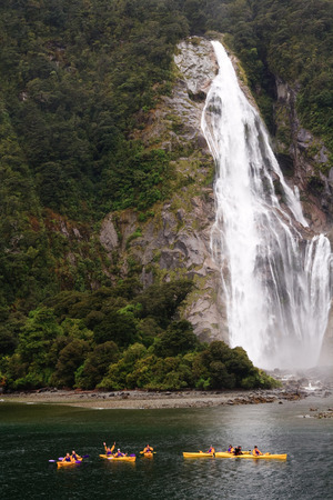 Kayaks by waterfall in beautiful Milford Soundの写真素材