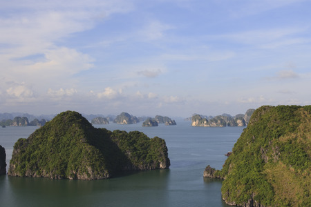 Island cliffs rise out of the ocean in Halong Bay, Vietnamの写真素材