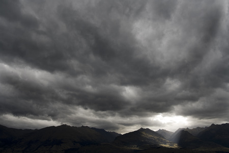 Dark moody sky over mountain range landscapeの写真素材