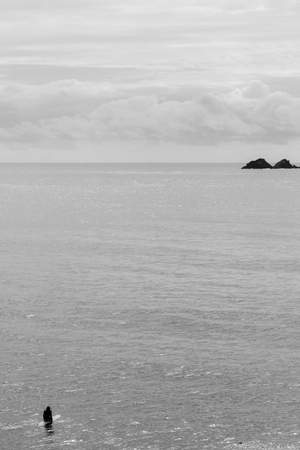 Surfer awaits swell in open water alone, Byron Bay, Australia. Black and Whiteの写真素材