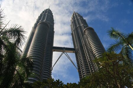 Foreground trees and leaves with centre view of Petronas Towers in backgroundのeditorial素材