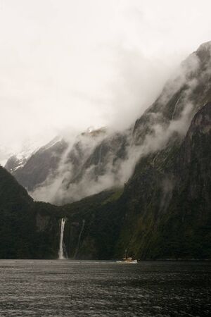 Boat cruise past cliffs in beautiful milford soundの写真素材