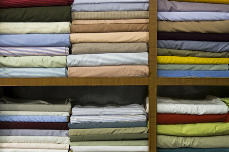Shelves stacked with different shirt fabricsの写真素材