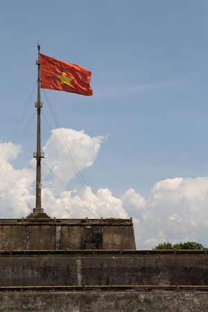 Vietnam flag standing on flag pole above historic Hue Citadel wallの写真素材