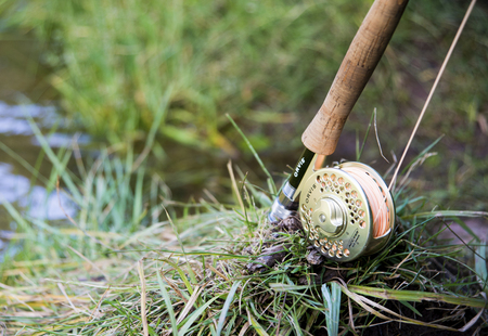 Fly fishing rod and reel closeup, on grass next to streamのeditorial素材