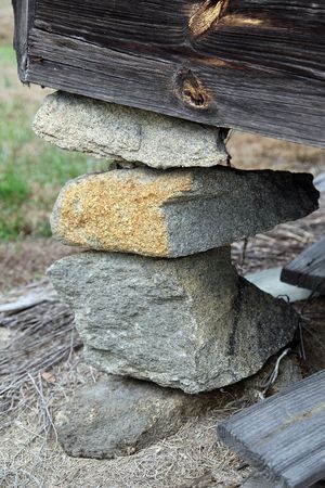 An old house rests on a delicate foundation of stones and rocks.の写真素材