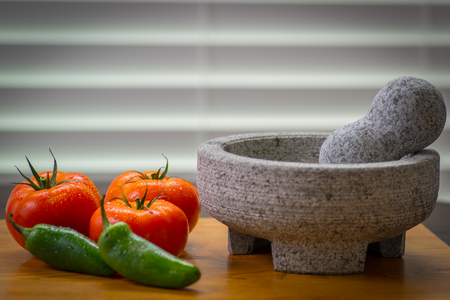 Zesty salsa with tomato and peppers, pico de gallo molcajete (mortar) and tejolete (pestle)の写真素材