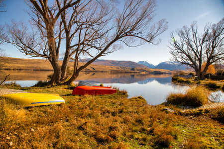 Two rowing boats adding a splash of colour to the scenic lake landscapeの写真素材