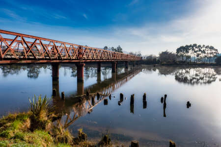 Historic Henley suspension bridge over the river Taieri at Otokai in the early morningの写真素材