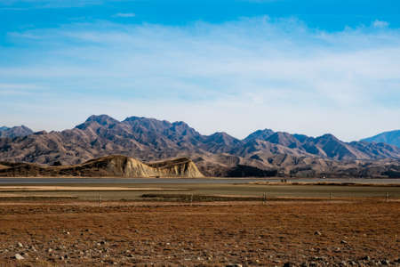 The extreme arid dry terrain around Lake Grassmere with a  dramatic rugged mountain as a backdrop