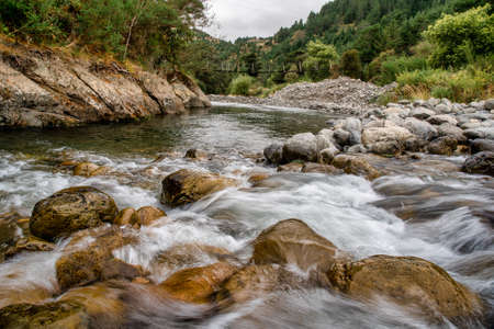 Powerful cascade of water in the river rapids in the natural remote desolated native bush of the Forest ranges of Tararua districtの写真素材