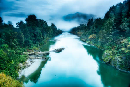 Dramatic moody cloudy weather settling in as darkness sets over the river  in the Buller Gorgeの写真素材
