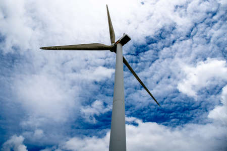 State highway heading  beneath the giant Wind turbines generating electricity on the hills of a rural agricultural farmの写真素材