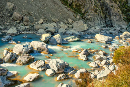The brilliant flowing turquoise water in the Hooker Valley river rapids, Aoraki Mt Cook National Parkin the Southern Alps of New Zealandの写真素材
