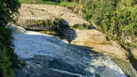 Standing almost on the edge of a powerful waterfallの写真素材