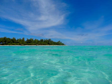The crystal clear blue turquoise water in the lagoon off Muri Beach and the offshore islandsの写真素材