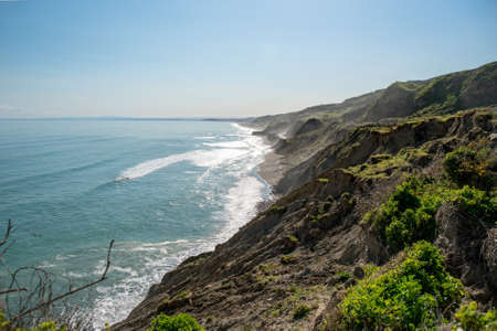 The dramatic crumbling high cliffs on the scenic Gisborne coastline on New Zealandの写真素材