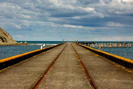 Railway tracks down the middle of Tokomaru bay wharf from a vanishing point perspectiveの写真素材