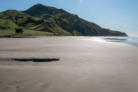 Clean pristine and empty beach leading to the promontoryの写真素材