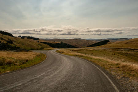 winding asphalt rural highway finding its way through dry agricultural farming countryの写真素材