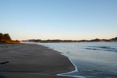 Early morning mist and sea fog rising of the ocean at Tolaga Bayの写真素材