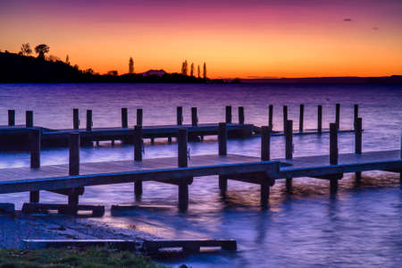 Dramatic colours of pre dawn over the piers and jetty at Turangi Lake Taupo New Zealand