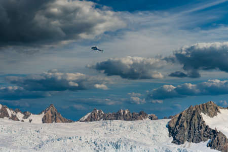 Helicopter flying over Franz Josef Glacier in New Zealand's Southern Alps