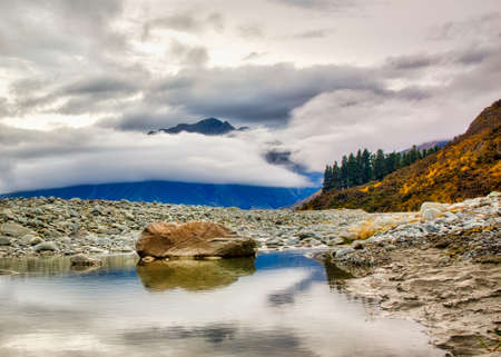 Reflections in a rock pool in the Clyde river in summer with almost no water near Erewhon Station, Ashburton NZの写真素材
