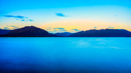 Long exposure at Lake Brunner very early morning as the sun rises above the Southern Alps mountain range  at sunriseの写真素材