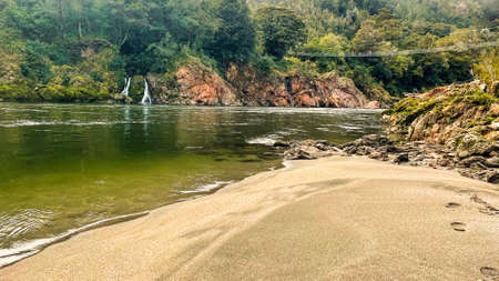 A group of tourists crossing the river on the Longest swing bridge in NZ in the Upper Buller gorgeの写真素材