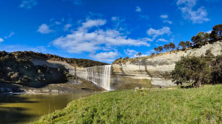 The size of the people in the shot give some perspective to the size of the Mangatiti waterfall cliff face at Pongaroaの写真素材